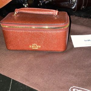 Coach jewelry box on metallic currant.